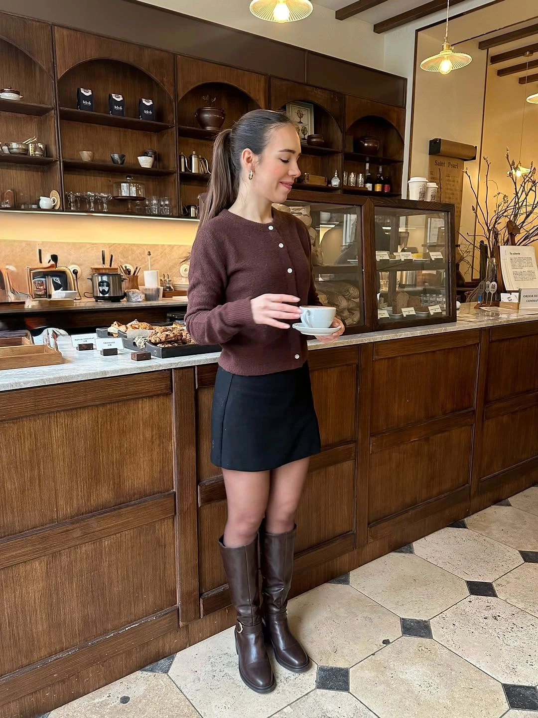 Brown cardigan with black short skirt and tall brown boots