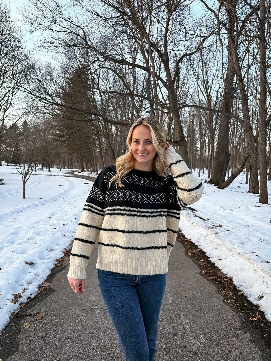 Black and cream striped sweater with jeans and dark footwear