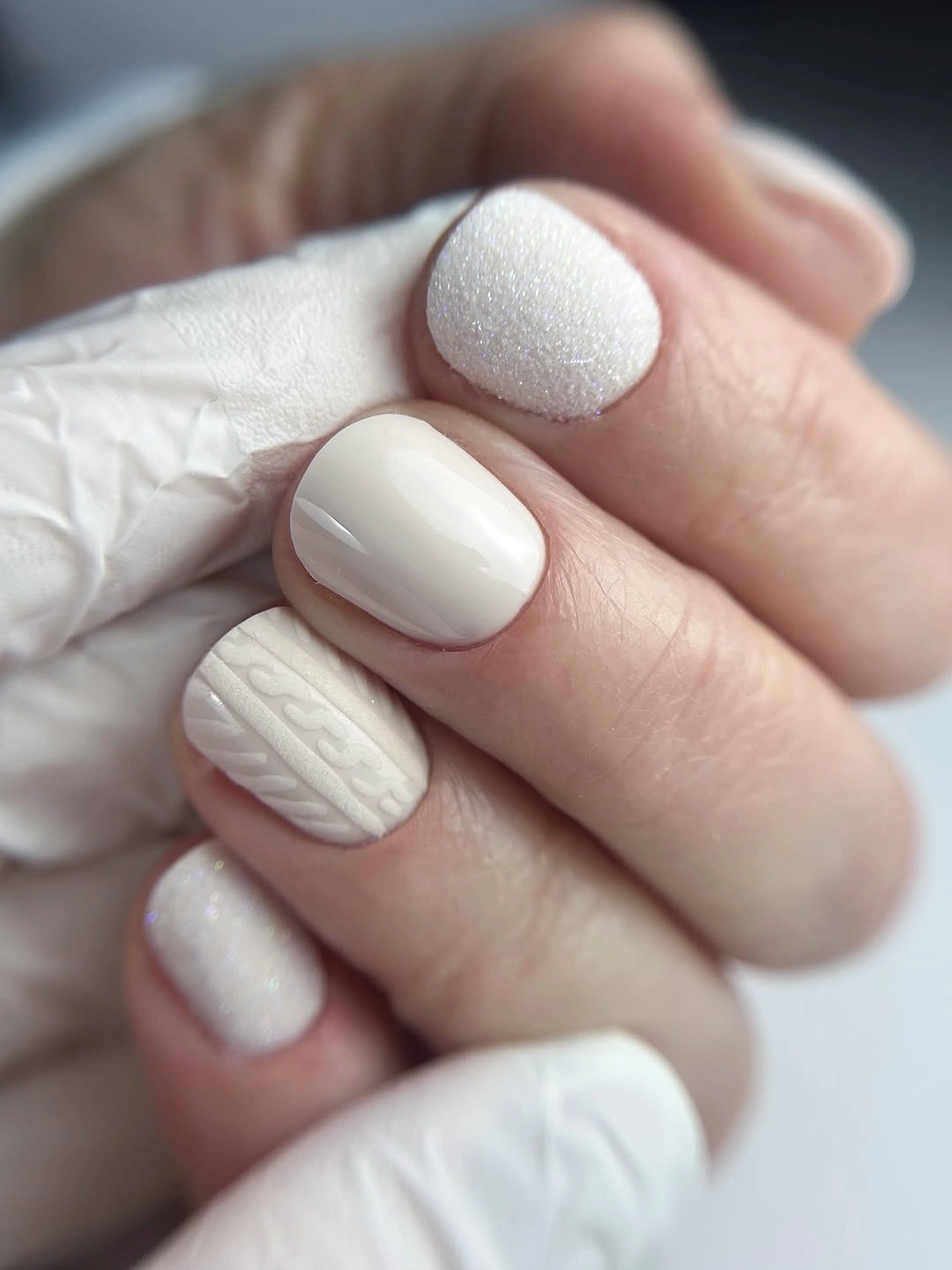 Short white nails with glossy, shimmer and knit-texture finishes