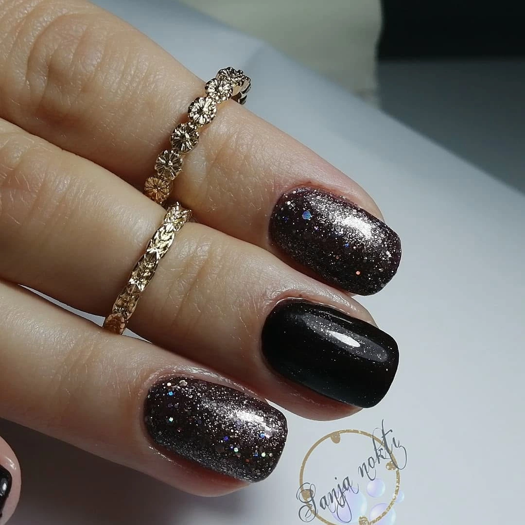 Short dark square nails with black polish and smoky glitter