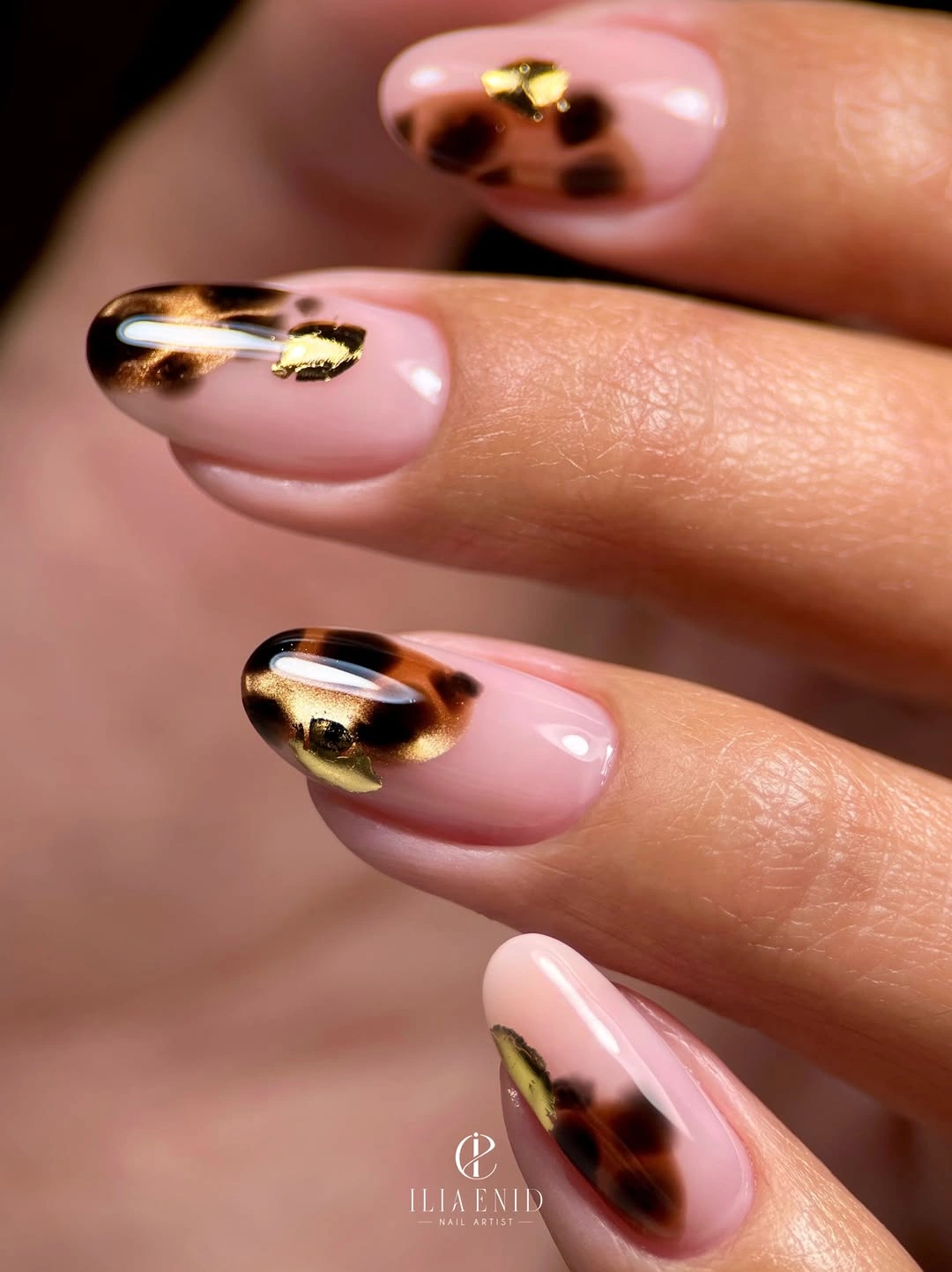 Pale pink almond nails with tortoiseshell tips and gold accents