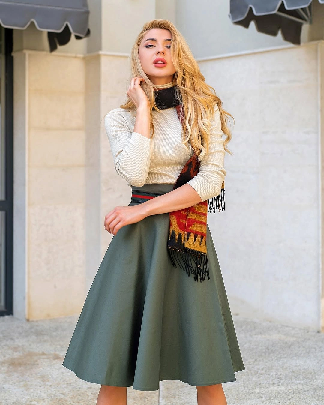 Long black coat, black skirt, yellow beanie, burgundy shoes, and bag