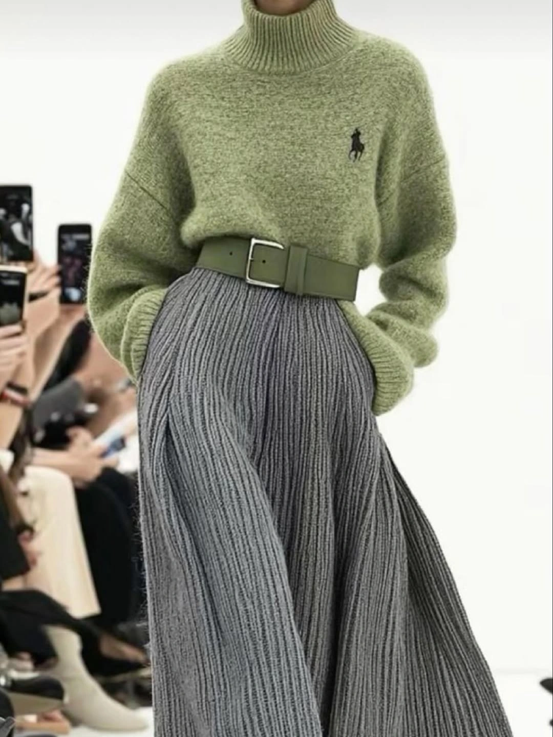 Sage turtleneck, wide green belt, and long gray pleated skirt