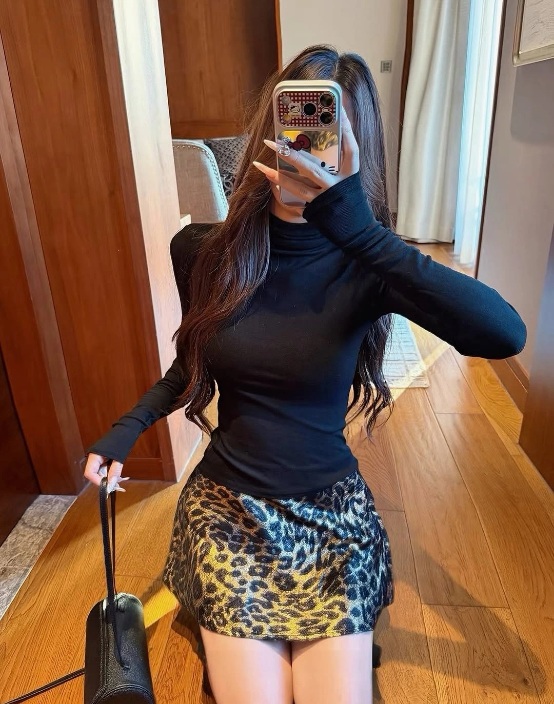 Black fitted turtleneck, leopard-print mini skirt, and black handbag