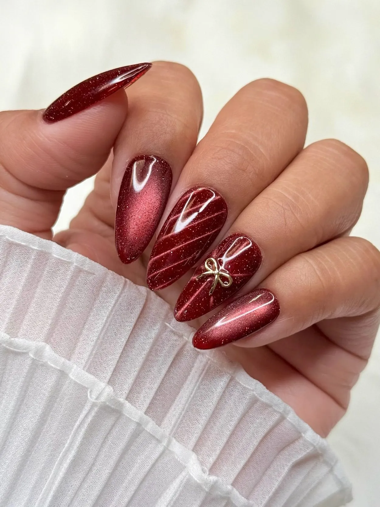 Deep Red Cat-Eye Stilettos with Gold Bow — Winter Date Night Nails