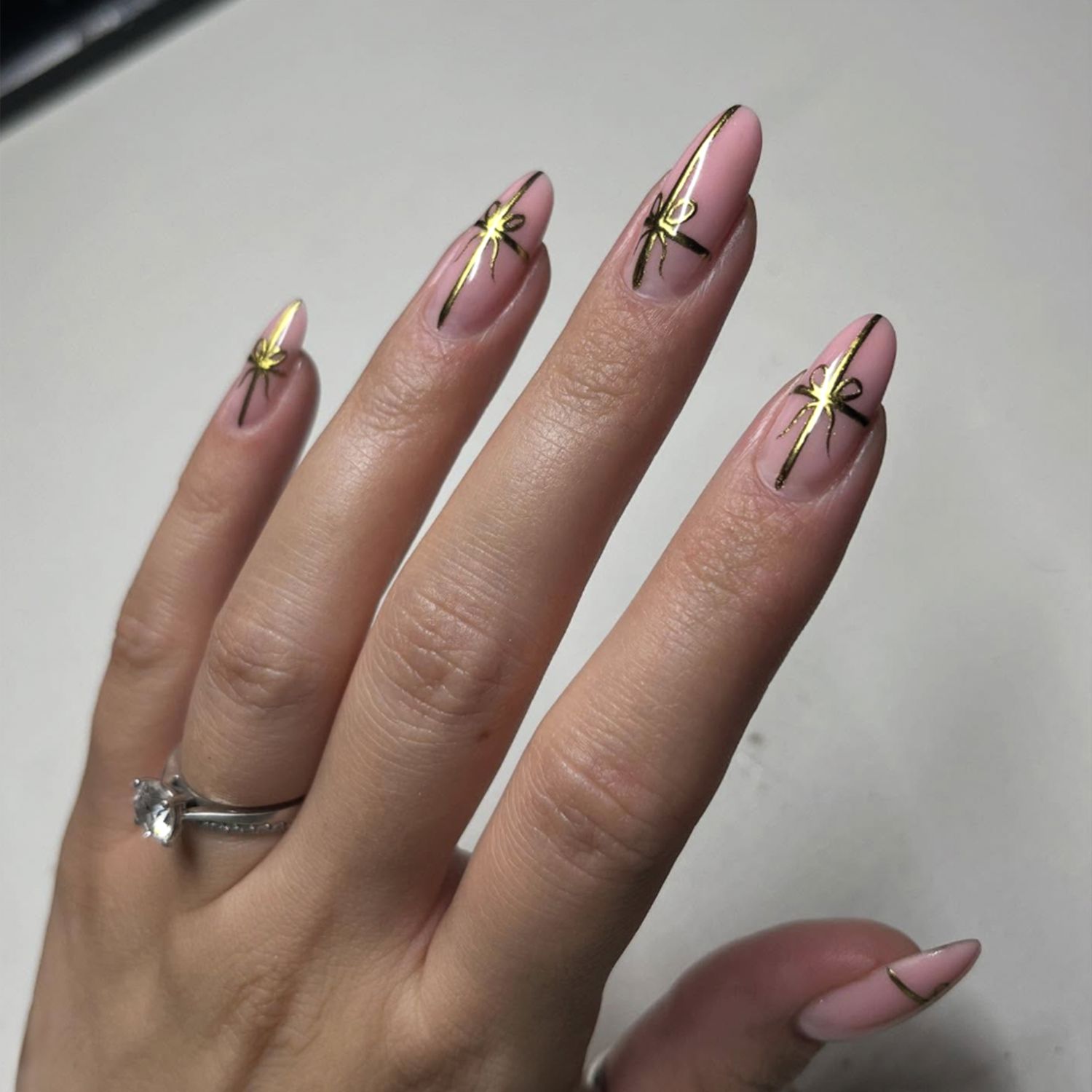 Pale Pink with Gold Bow Decals Almonds Pale Pink with Gold Bow Decals Almonds β Christmas Nails for Women Over 50 2026