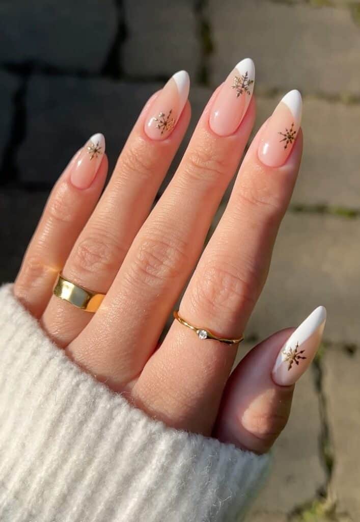 Sheer Pink French with Gold Snowflakes Sheer Pink French with Gold Snowflakes β Long Winter Almond Nails
