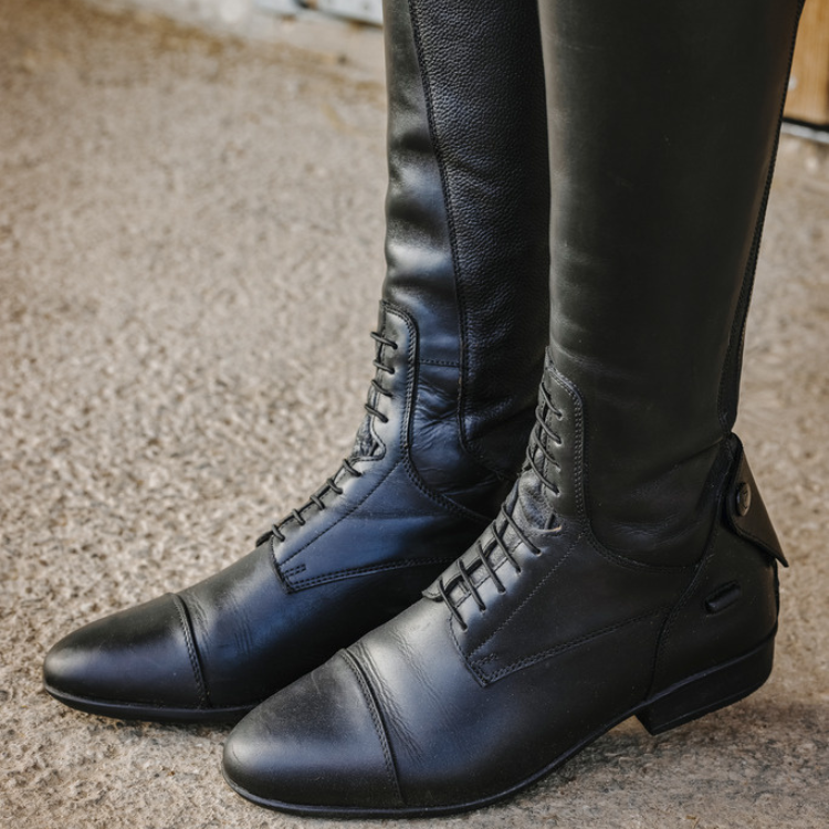 Detailed Lacing: Black Riding Boots on Textured Ground Detailed Lacing: Black Riding Boots on Textured Ground β Riding Boots Outfits
