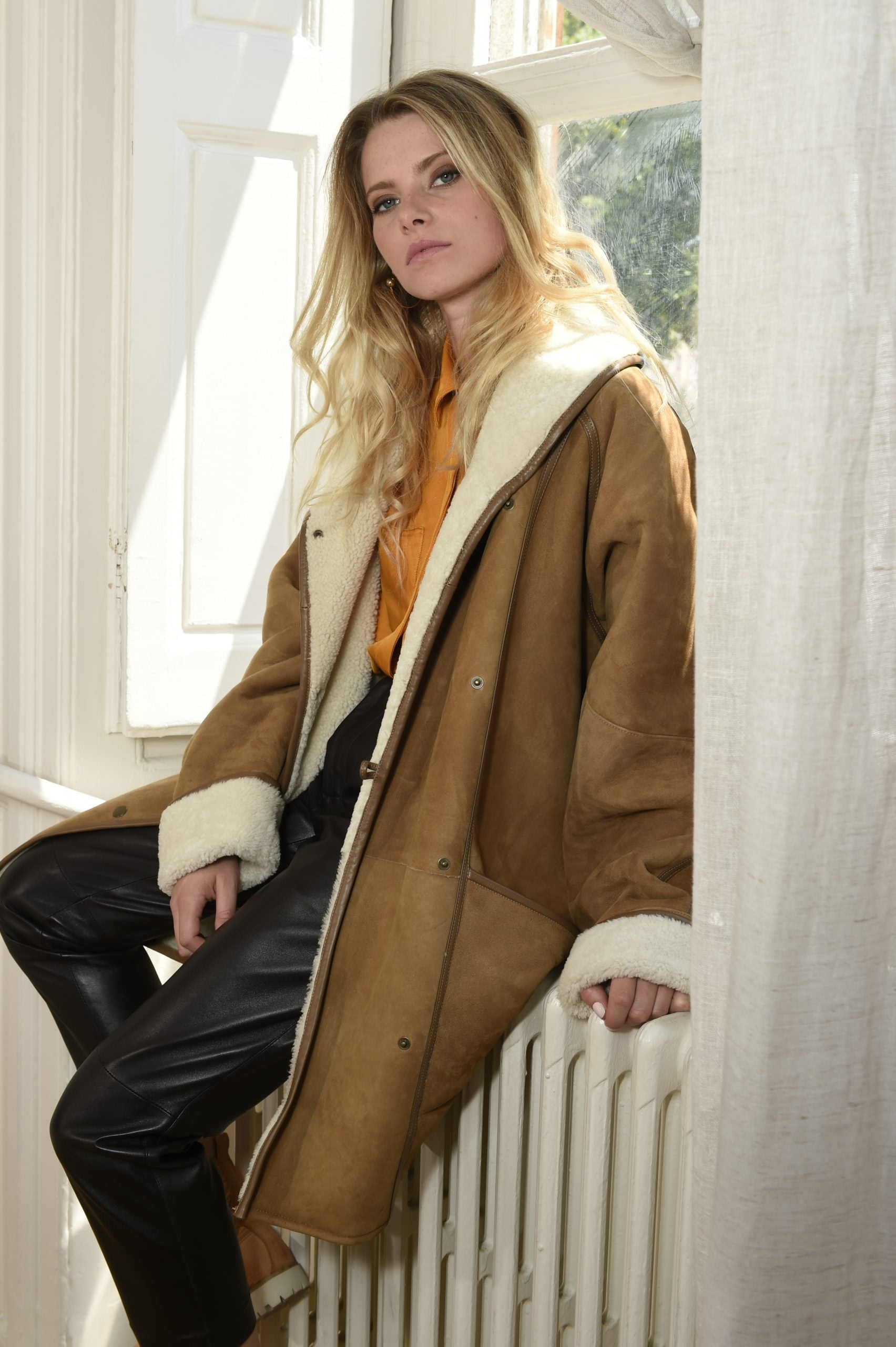 Brown Shearling Coat Worn Over White Cable Knit Sweater — Shearling Coat Outfits