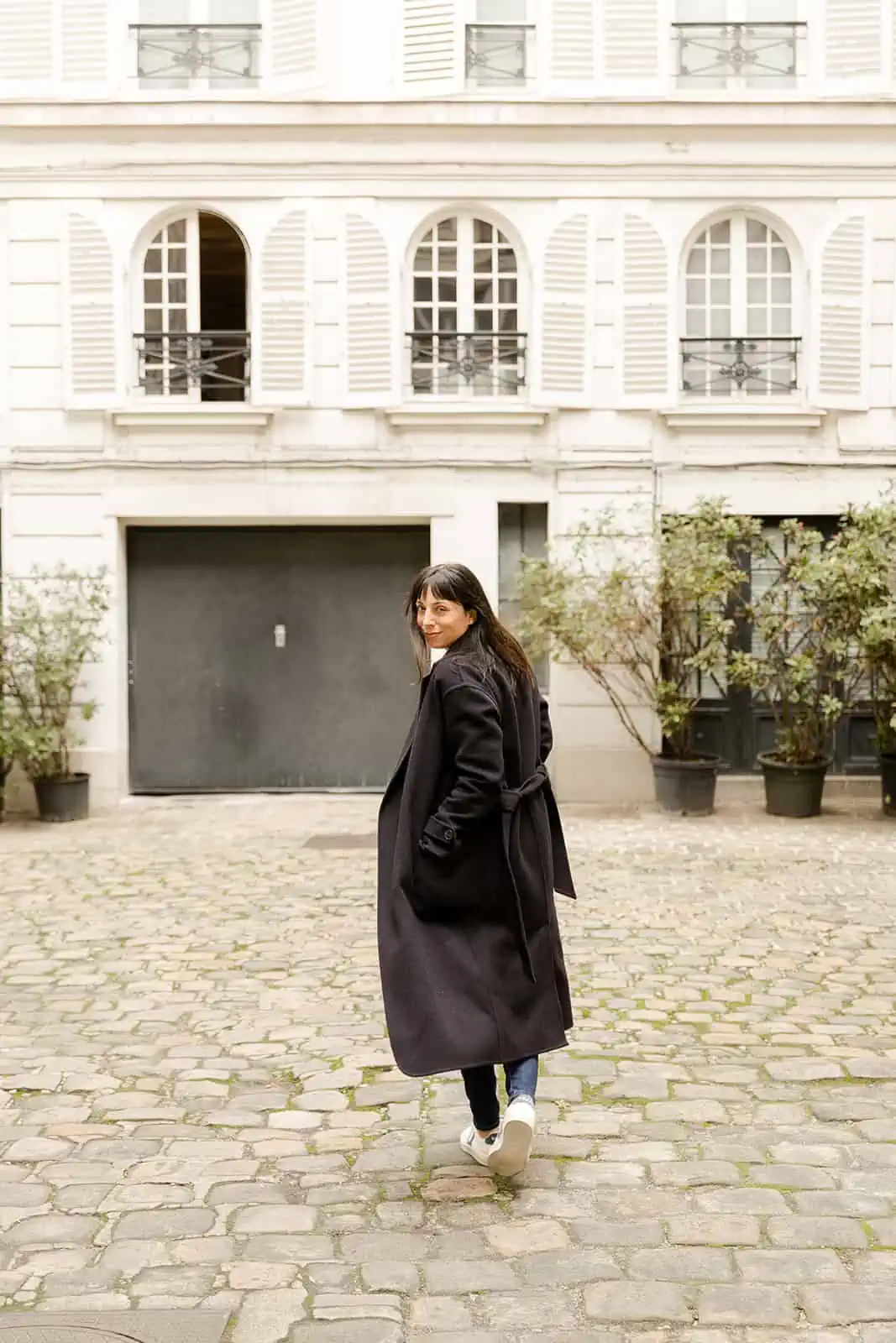 Simple Dark Belted Coat with Jeans and White Sneakers — January Outfits