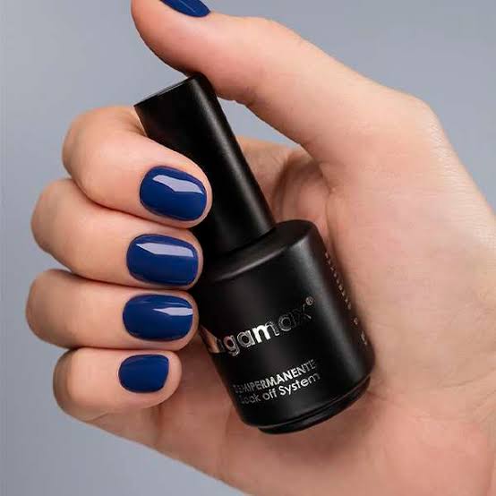 One Hand Holding A Nail Polish Bottle Deep Navy Blue Glossy Short Oval One Hand Holding A Nail Polish Bottle Deep Navy Blue Glossy Short Oval β Winter Nail Colors for Brown Skin