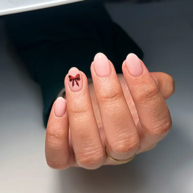 Pale Pink Oval Nails with Red Bow Sticker Pale Pink Oval Nails with Red Bow Sticker β Subtle Christmas Nails 2026