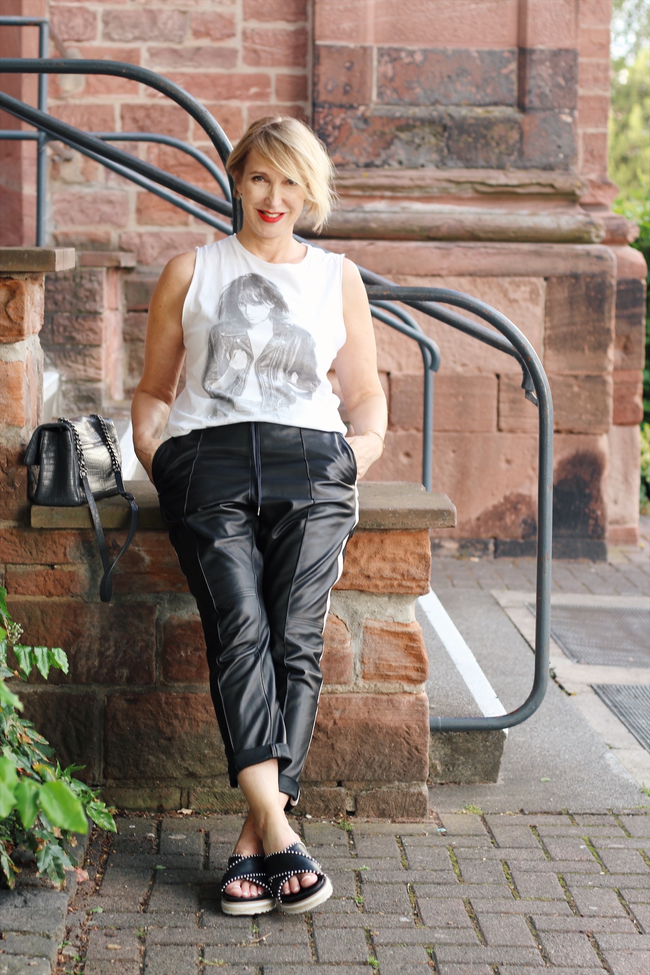 Black Leather Pants with White Side Stripes, Graphic Tee, and Slides — Leather Pants Outfits