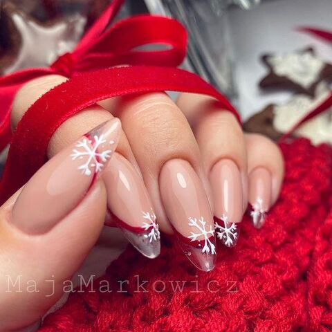 Glossy Nude French Tips with Snowflake Accents Glossy Nude French Tips with Snowflake Accents β Christmas Almond Nails 2026