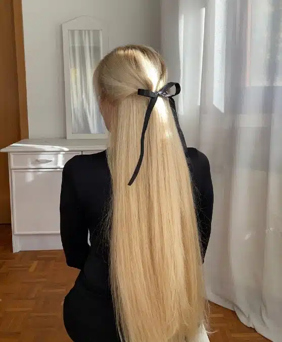 Wavy Medium Density Half Updo With Black Bow Accessory — Winter Hairstyles for Work