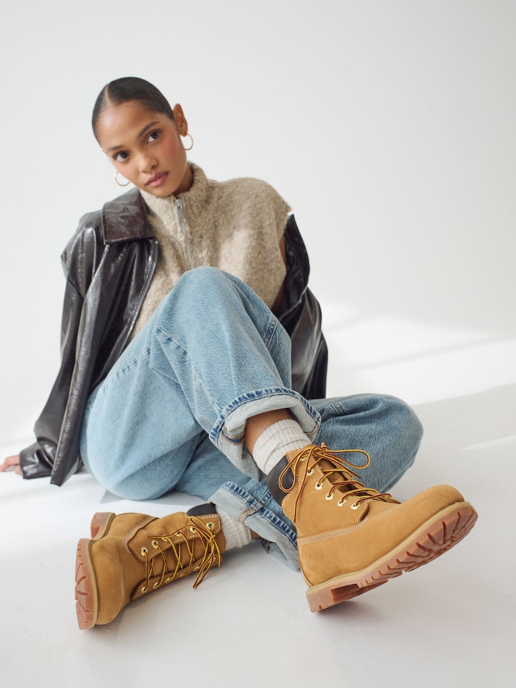 Chic Layering: Leather Jacket, Knit Vest, and Wide-Leg Jeans — Timberland Boots Outfits