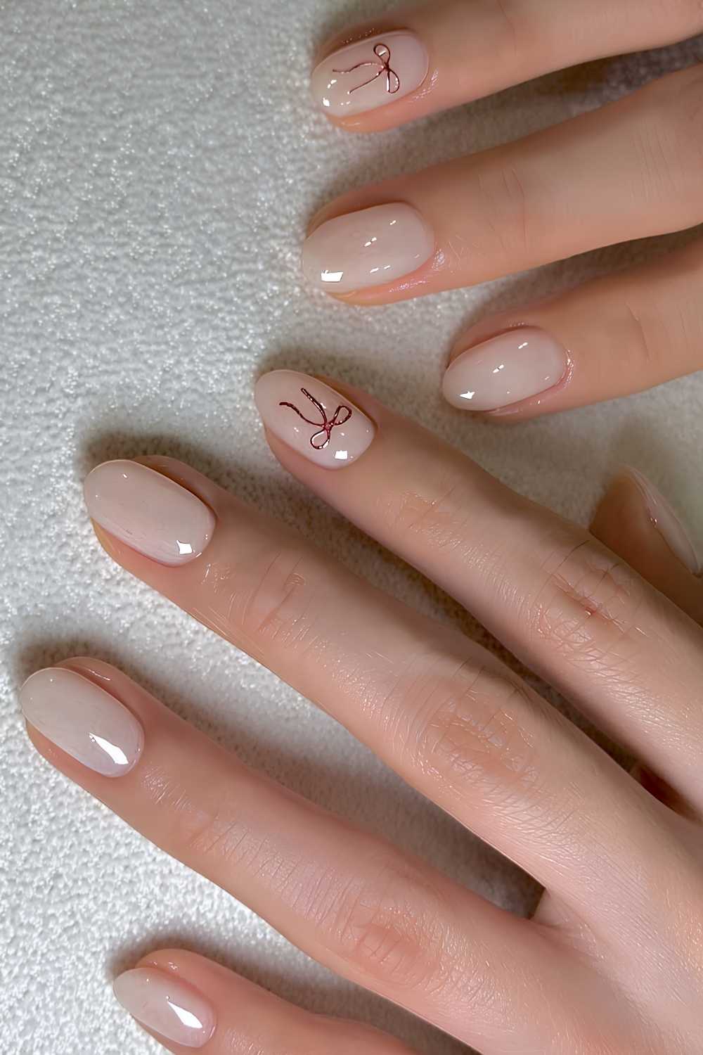Subtle Milky Nude with a Red Bow Accent — Cute Winter Nails