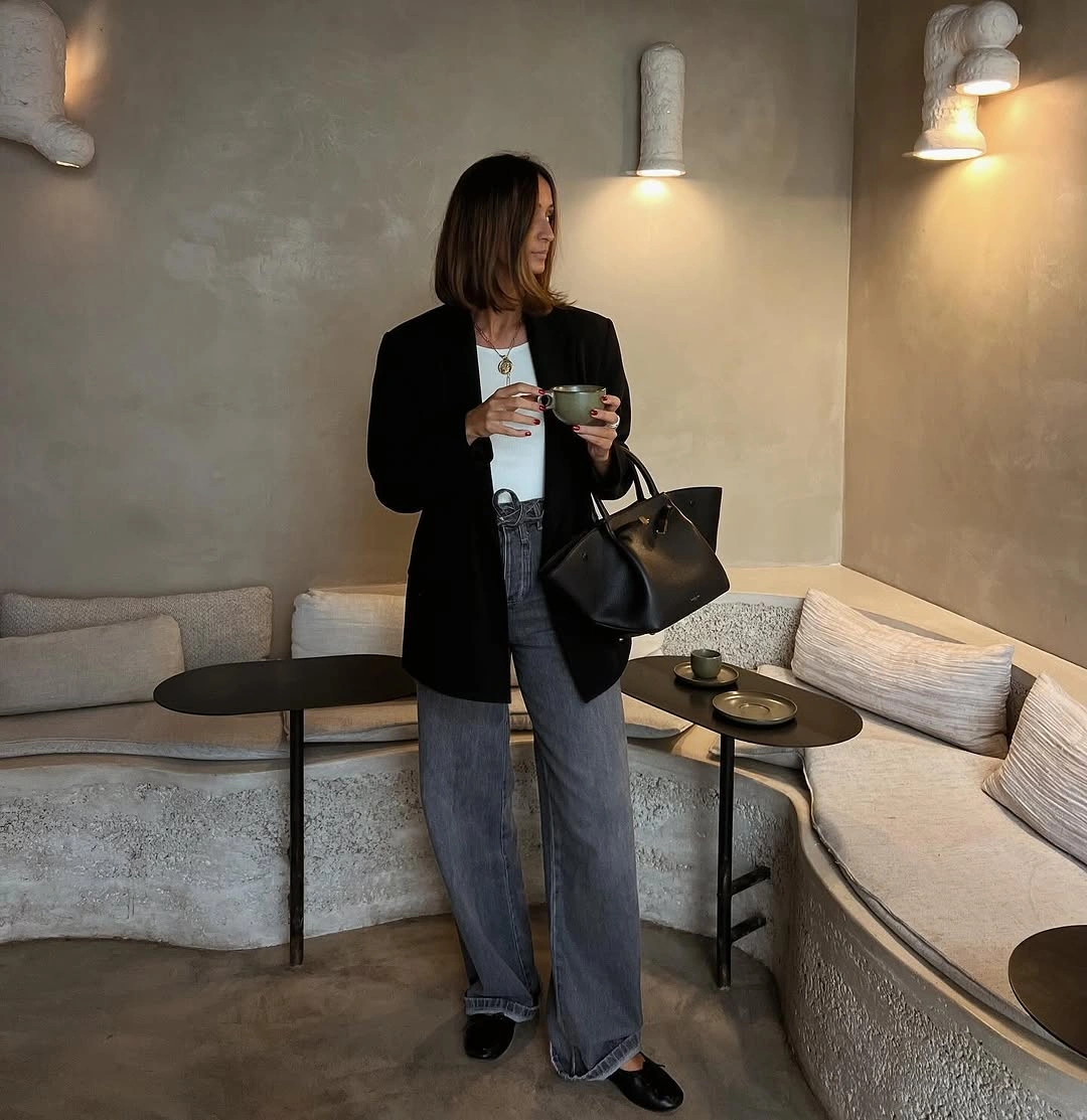 Black blazer over white top and loose blue jeans with loafers