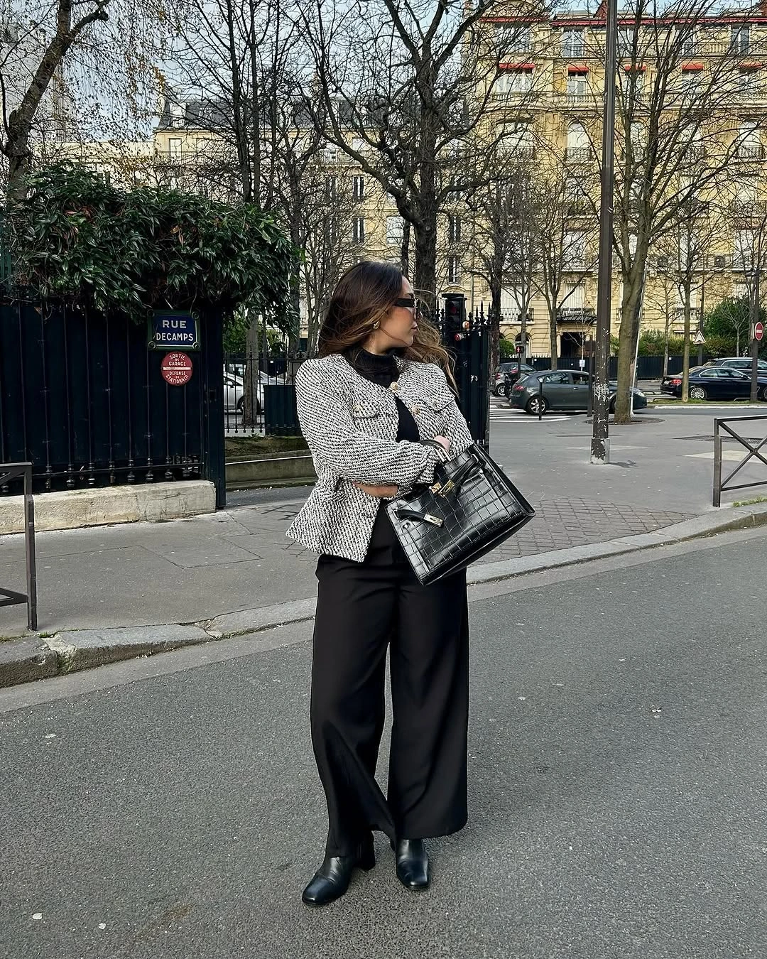 Textured gray fitted jacket over black top and wide black trousers