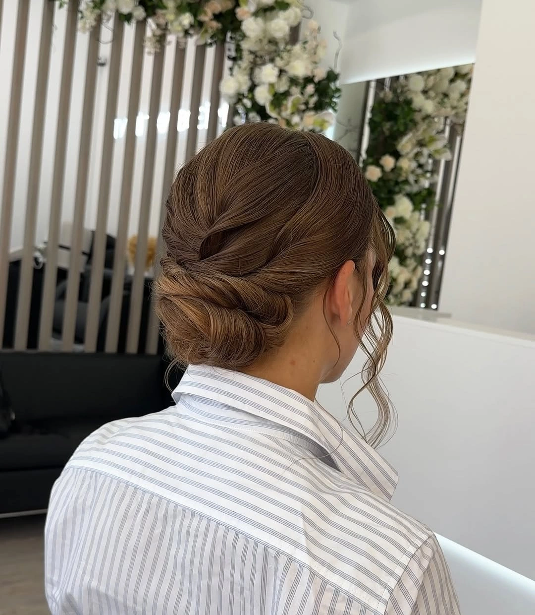 Brown hair swept diagonally into a compact low bun