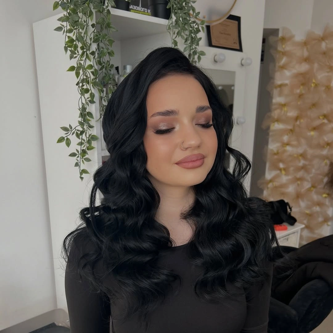 Long black hair with side part and deep glossy waves