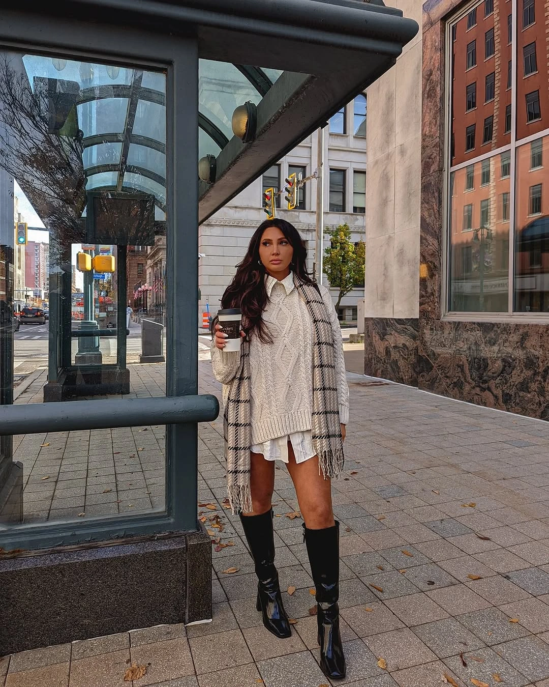 Cream cable-patterned long top with checked scarf white hem and tall black boots
