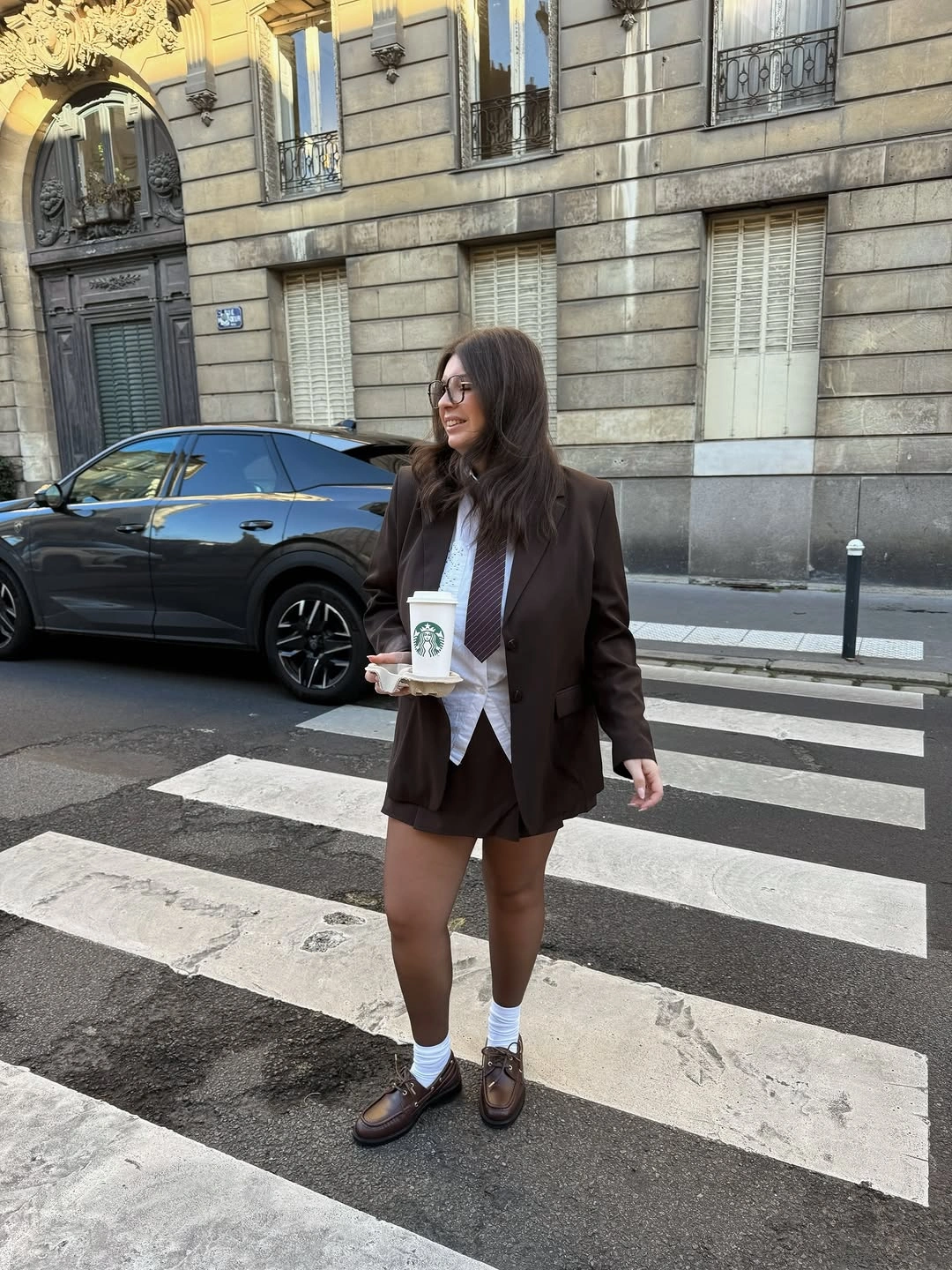 Brown oversized blazer white collared shirt dark tie short hem and loafers