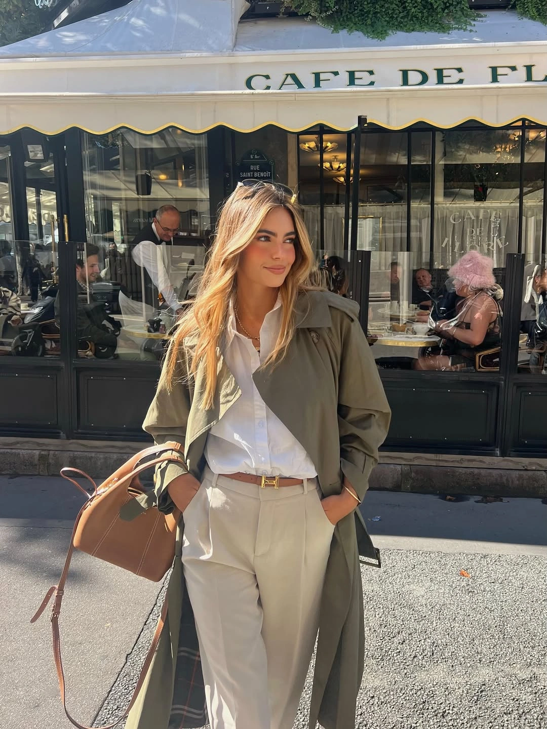 Olive coat white shirt cream trousers and tan handbag