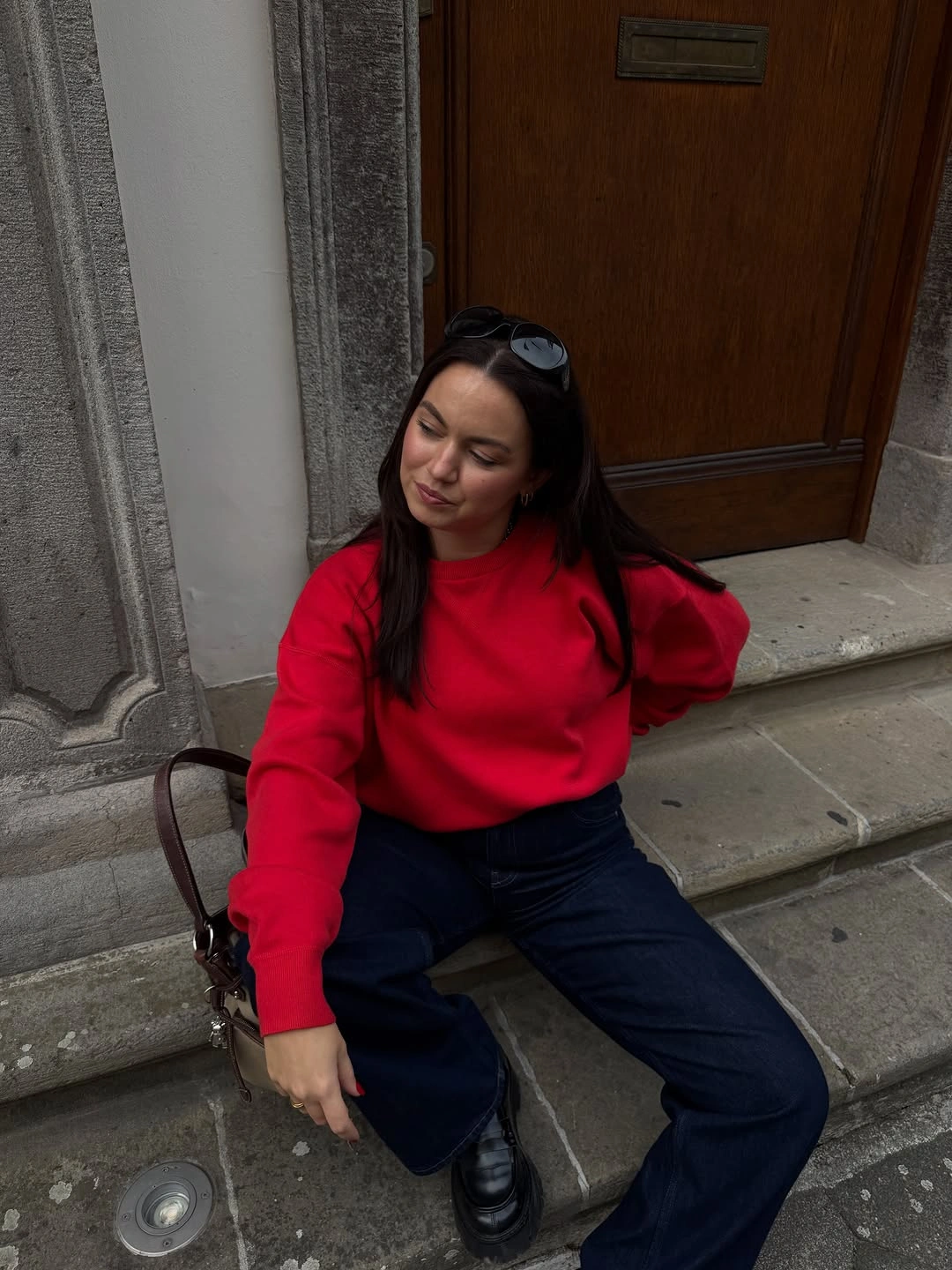 Red crewneck sweater dark wide-leg trousers and black shoes