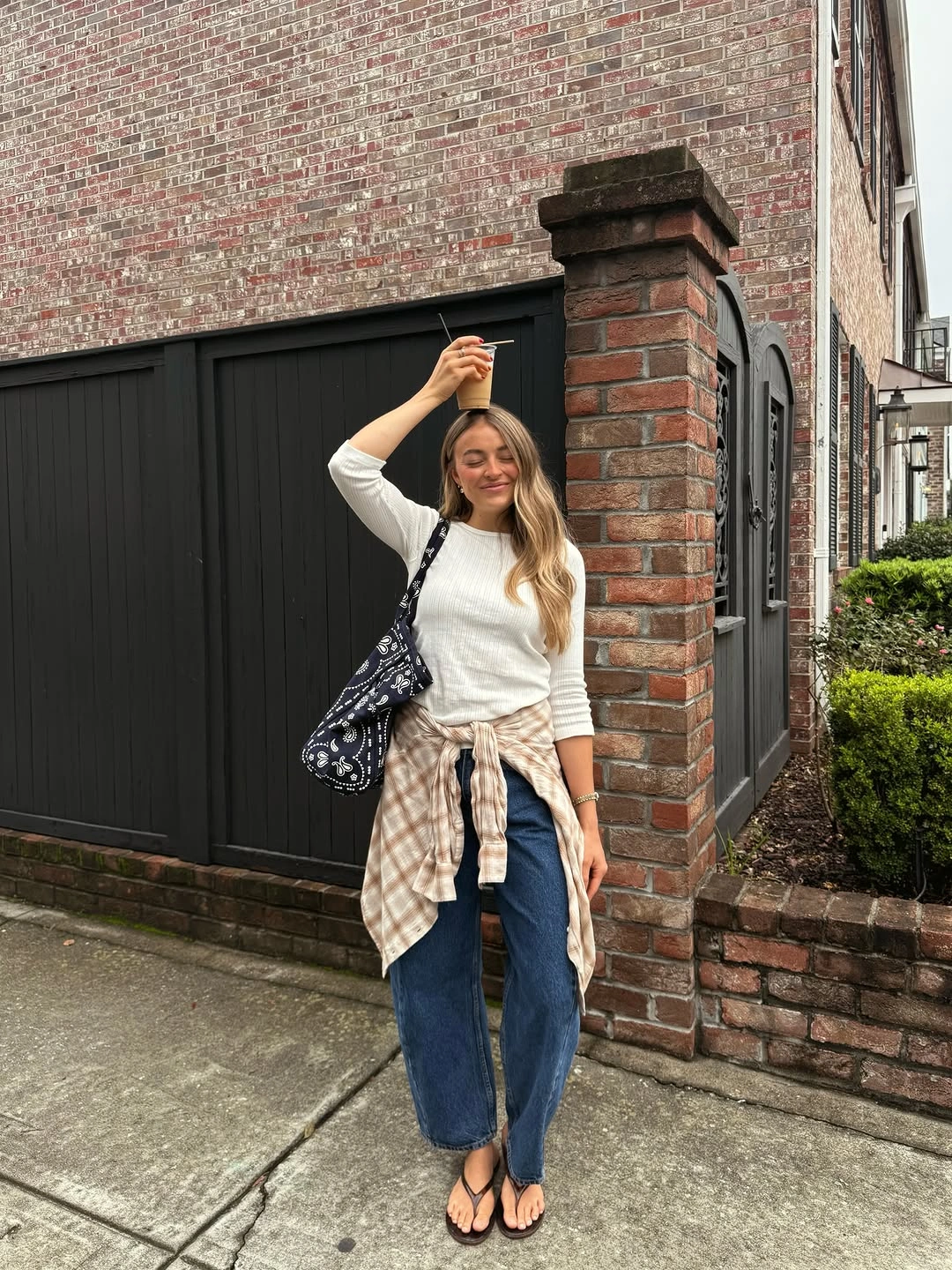 White sweater blue jeans plaid shirt and patterned tote