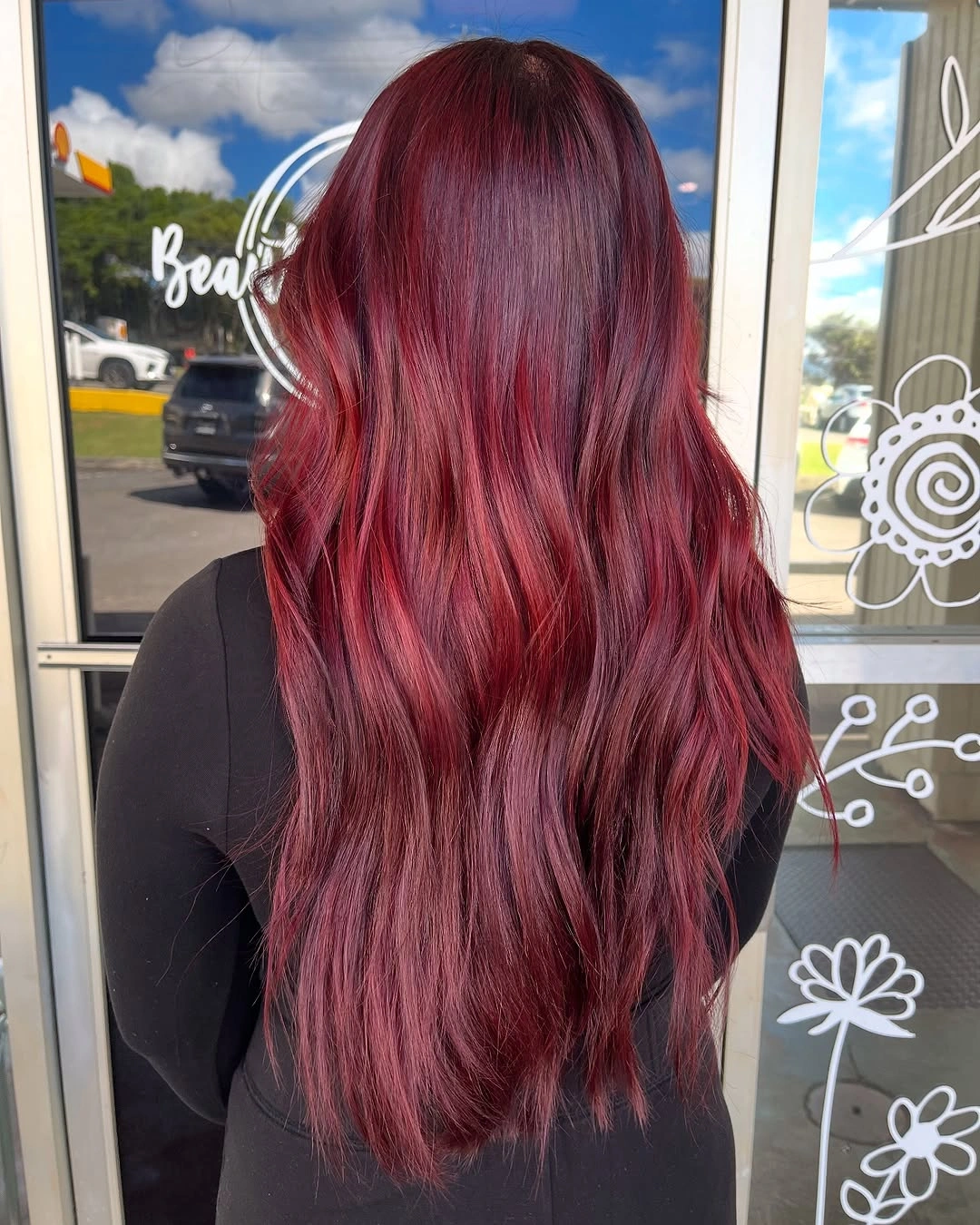 Long burgundy red hair with ruby highlights and loose layered waves
