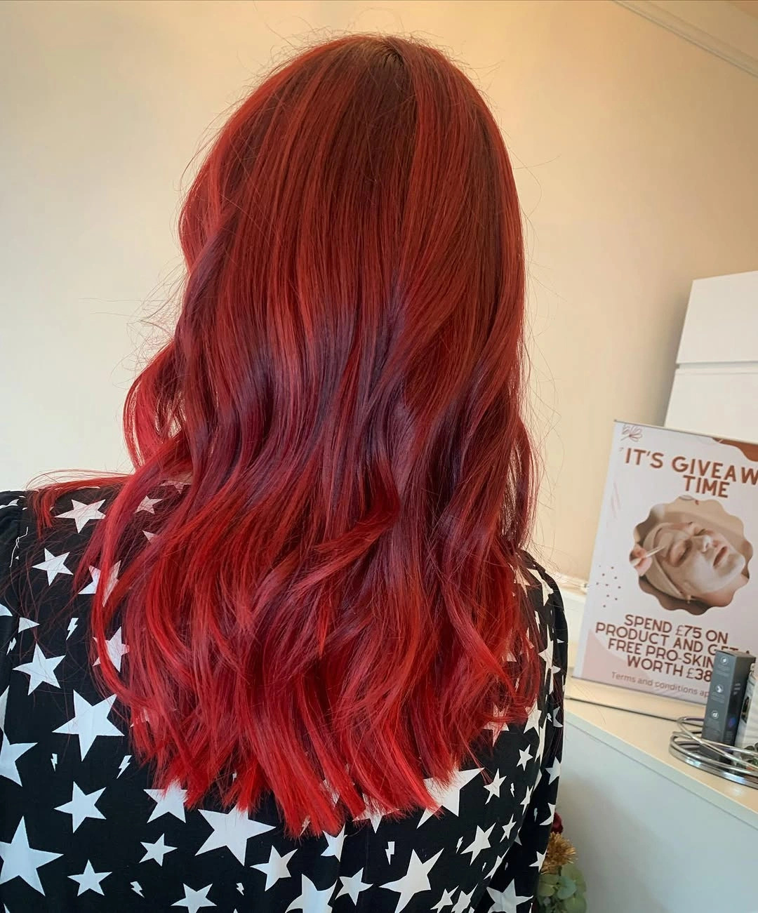 Medium length vivid cherry red hair with darker magenta tones and tousled waves
