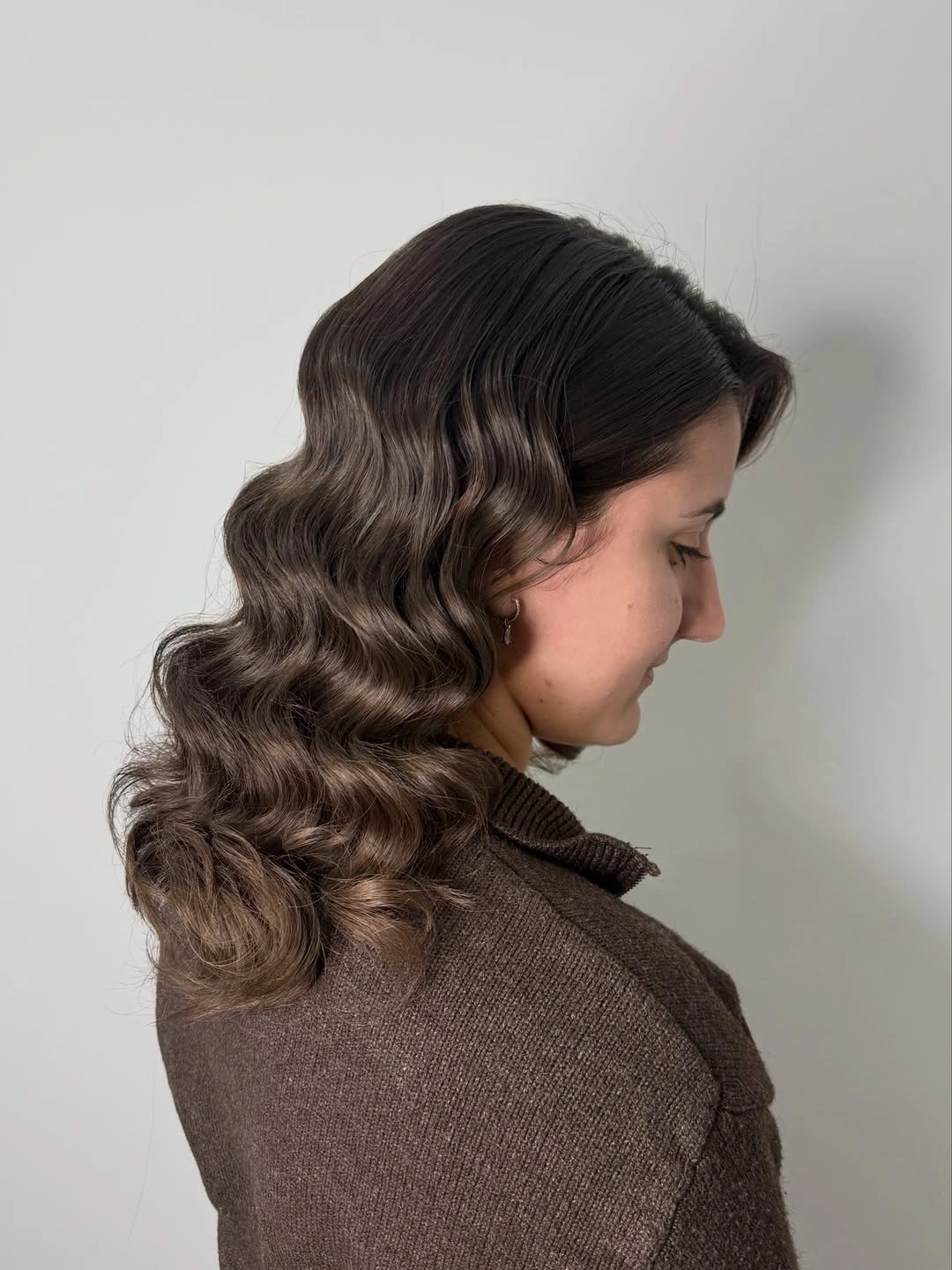 Medium length cool taupe brown hair with defined sculpted waves