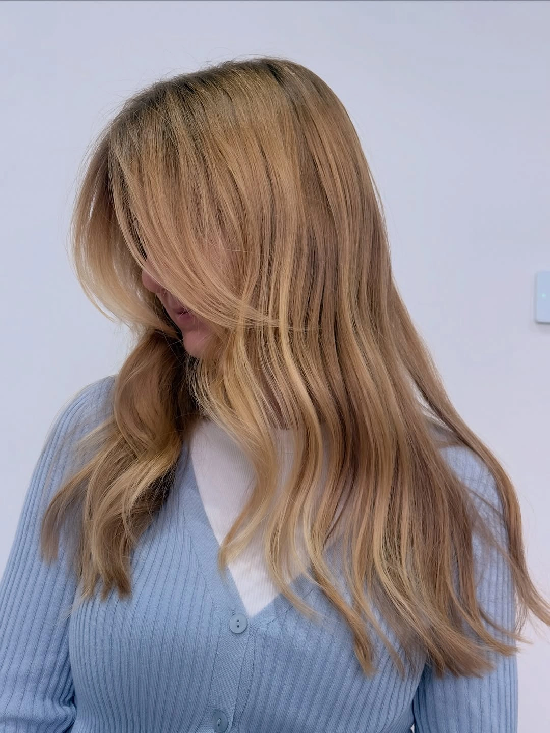 Medium long sandy beige blonde hair with layered fringe and relaxed lengths