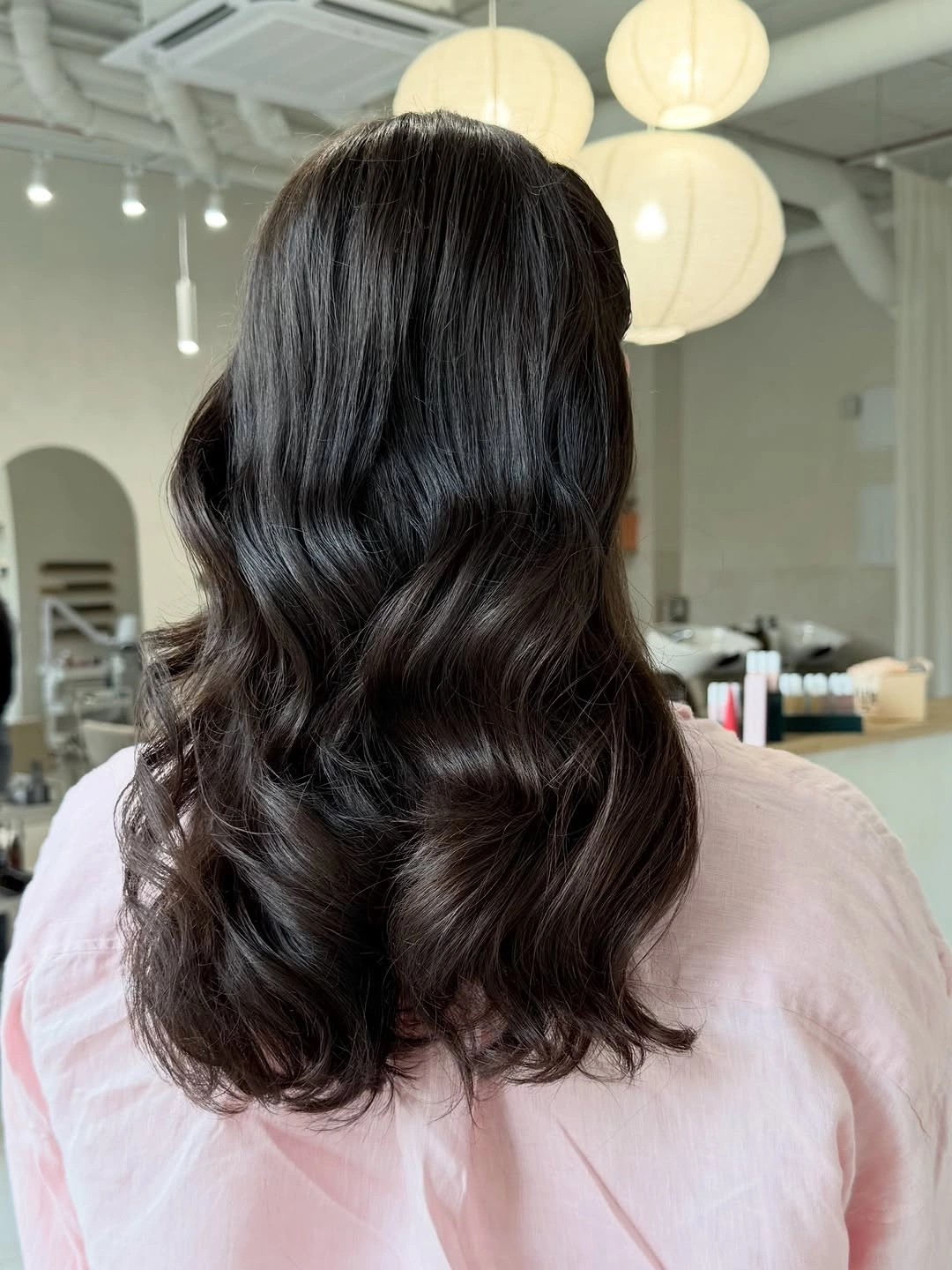 Medium length near black espresso brown hair with broad glossy waves
