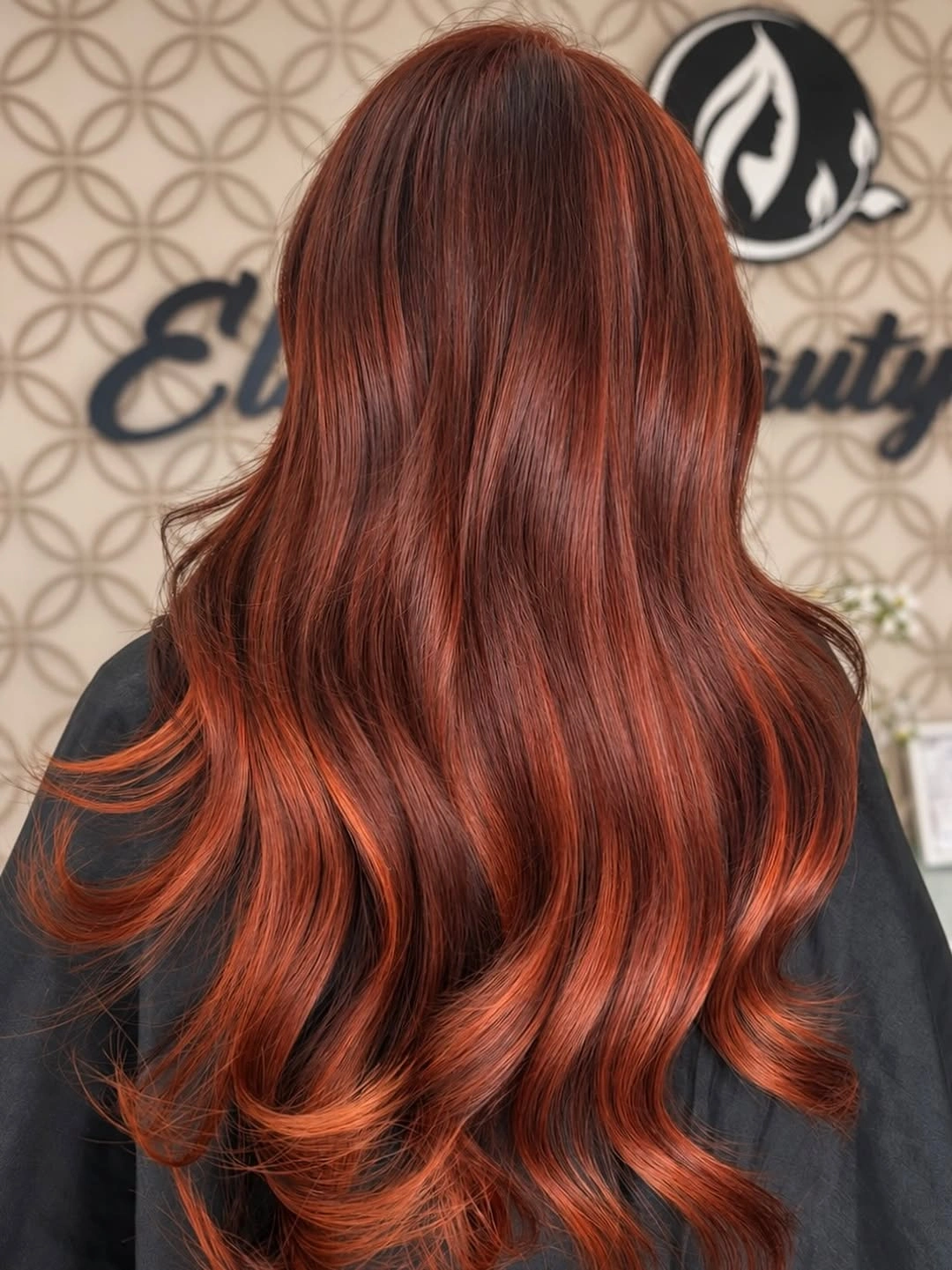 Long fiery copper red hair with auburn roots and bright orange waves