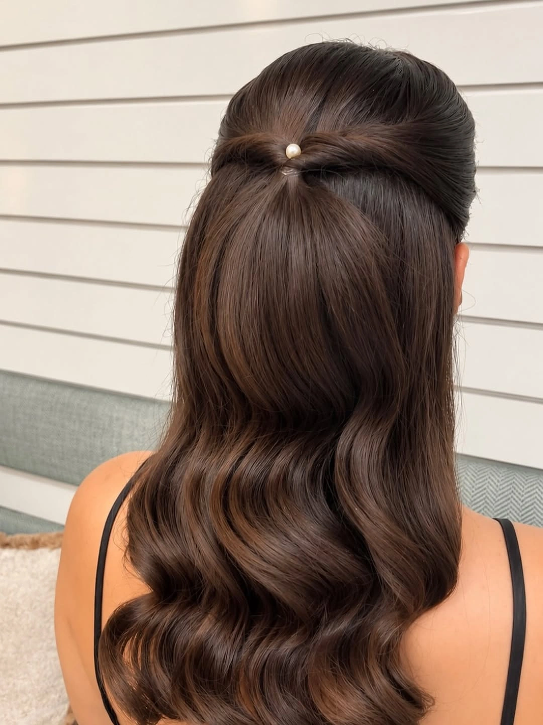 Dark chocolate brown hair with pearl accent and polished half up waves