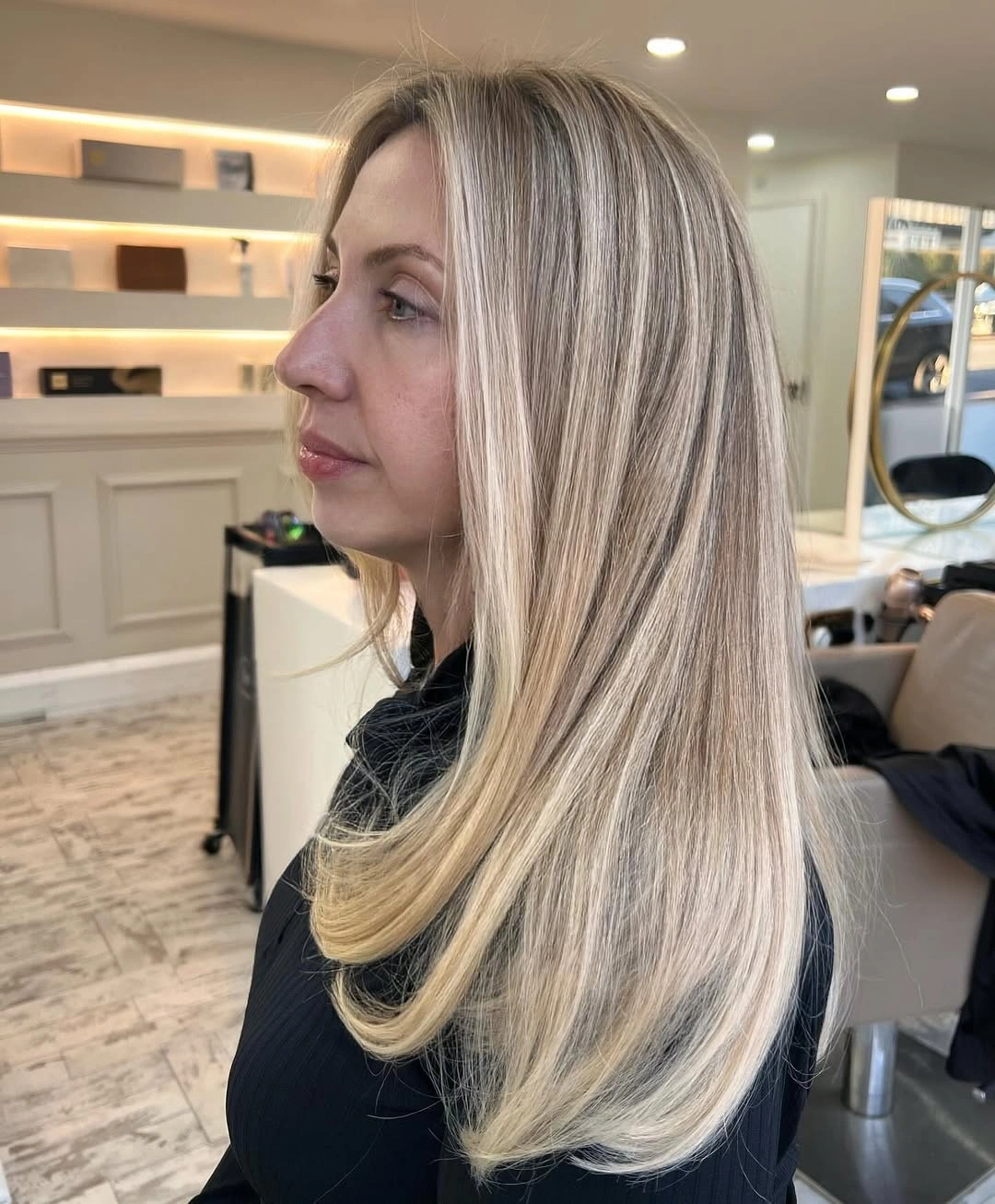 Long straight beige blonde hair with creamy highlights and curved layered ends