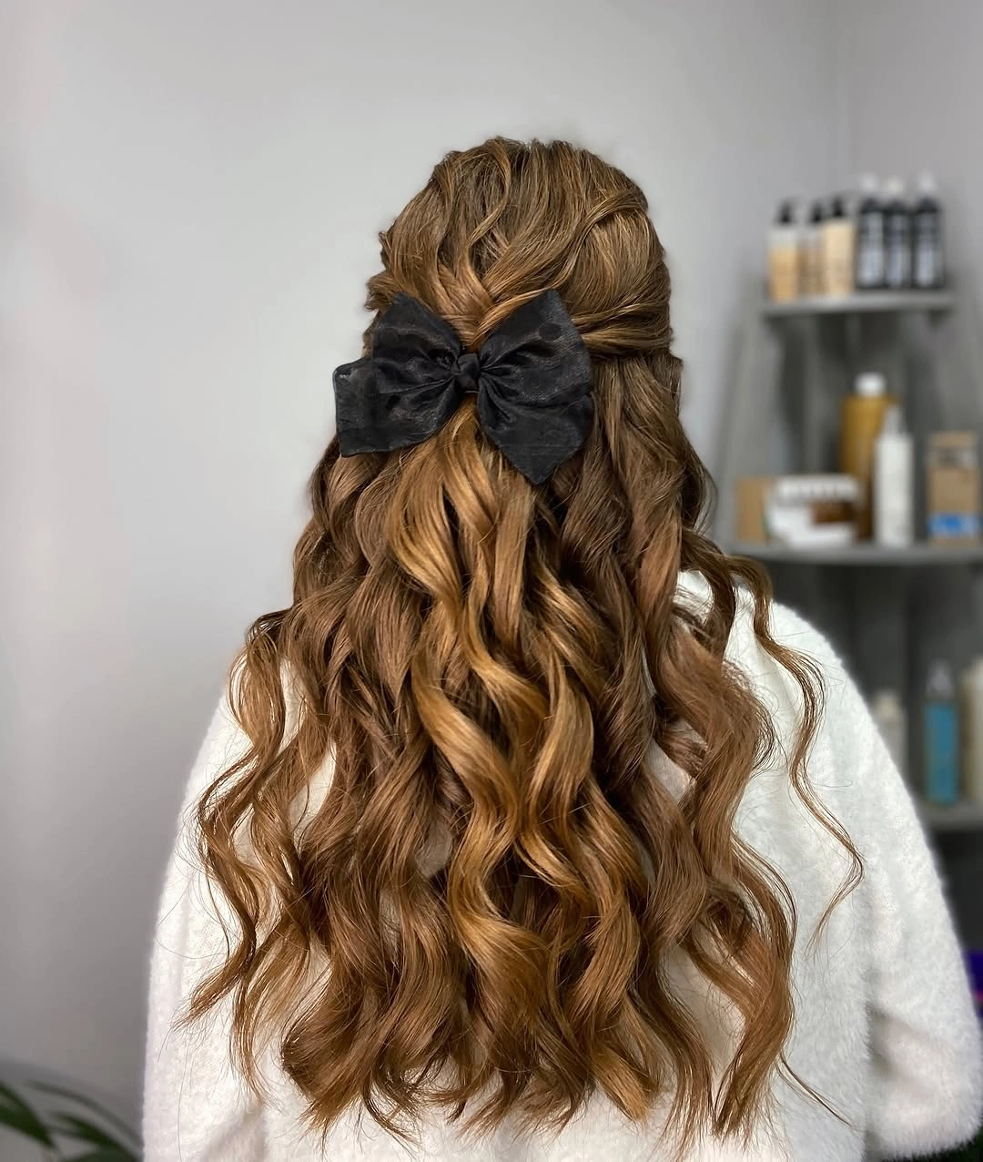Long copper brown curls with centered black bow and pulled back sides