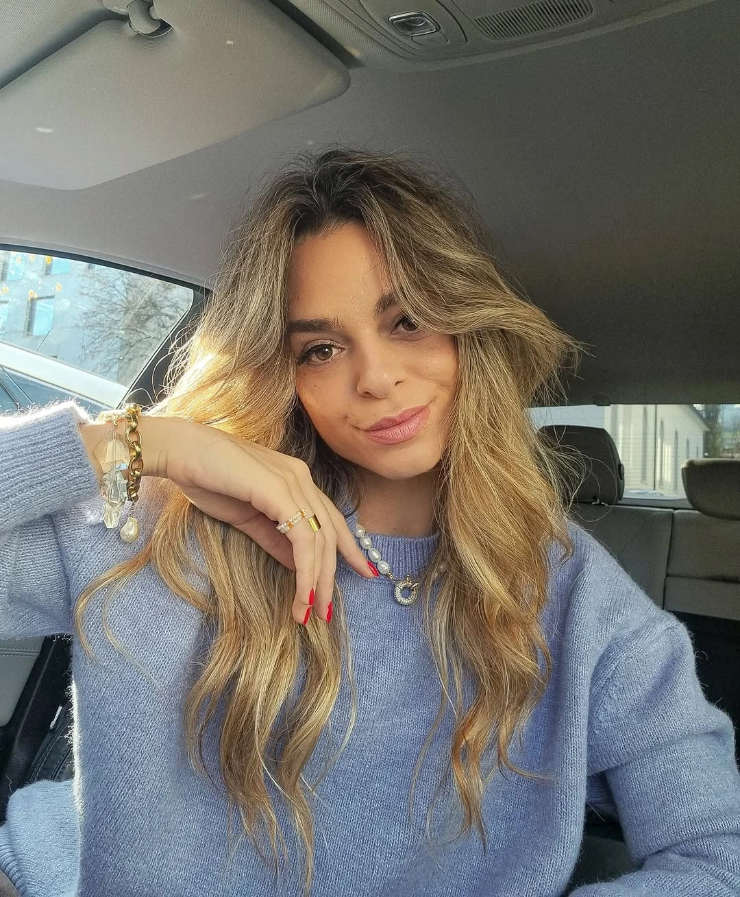 Long warm blonde hair with darker roots and relaxed irregular waves