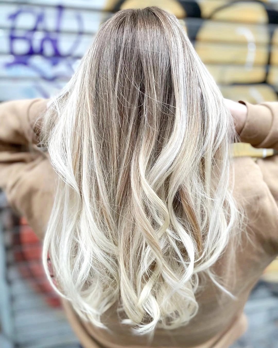 Very long pale ash blonde hair with darker roots and broad lower bends