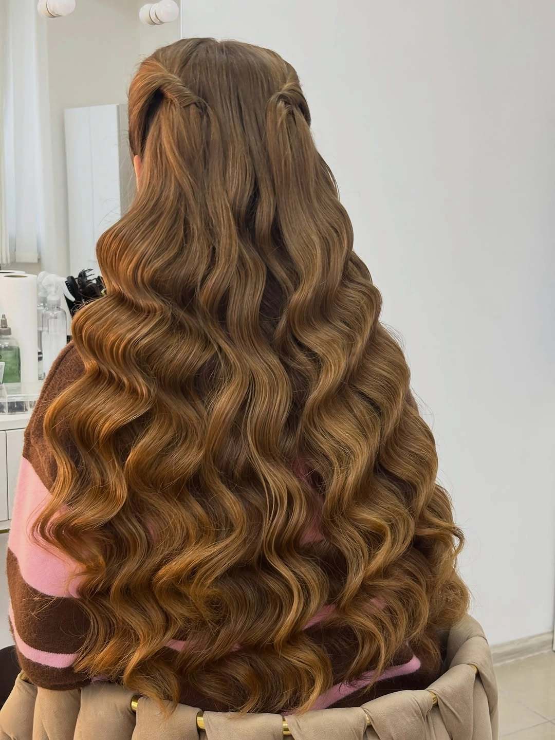 Very long caramel brown hair with broad waves and swept back sides