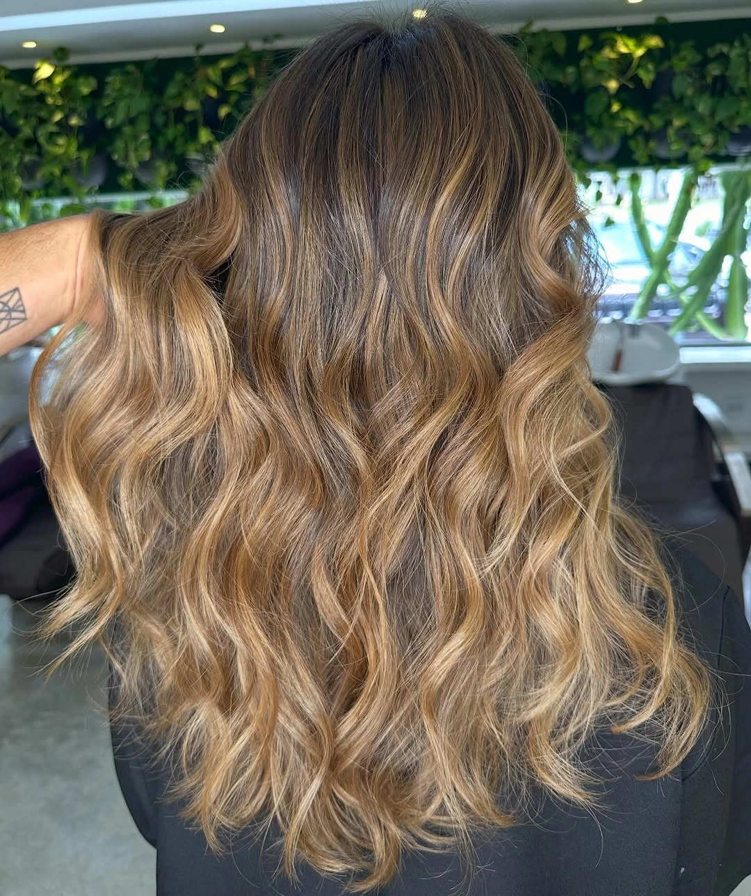 Long brunette waves with caramel honey highlights and darker roots