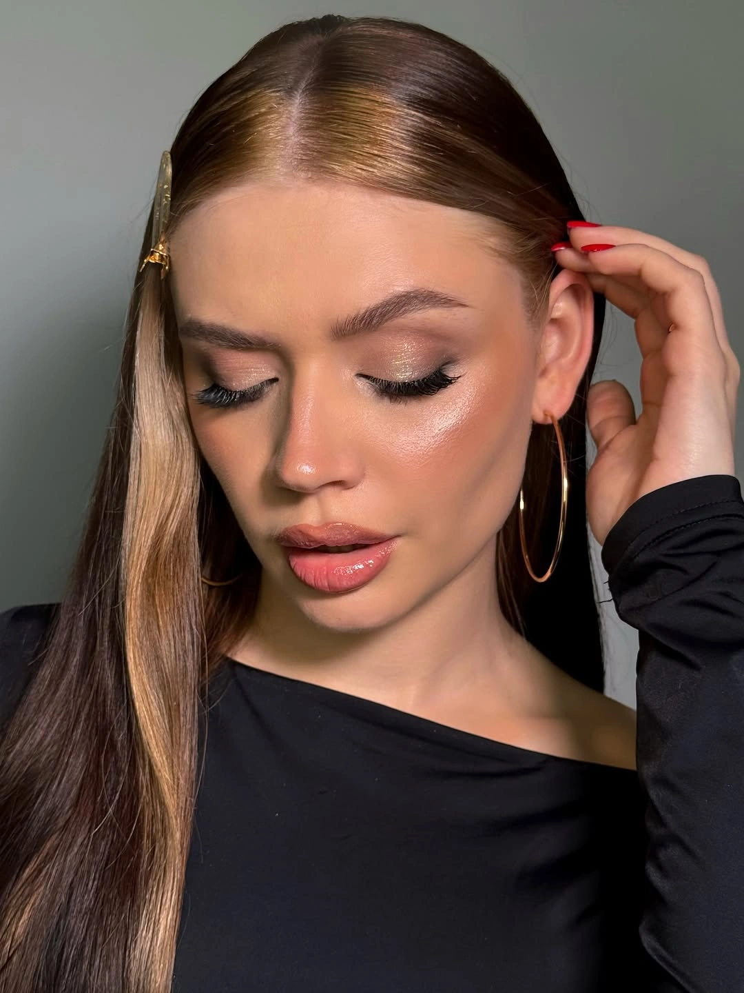 Long straight brown hair with center part and metallic side barrette