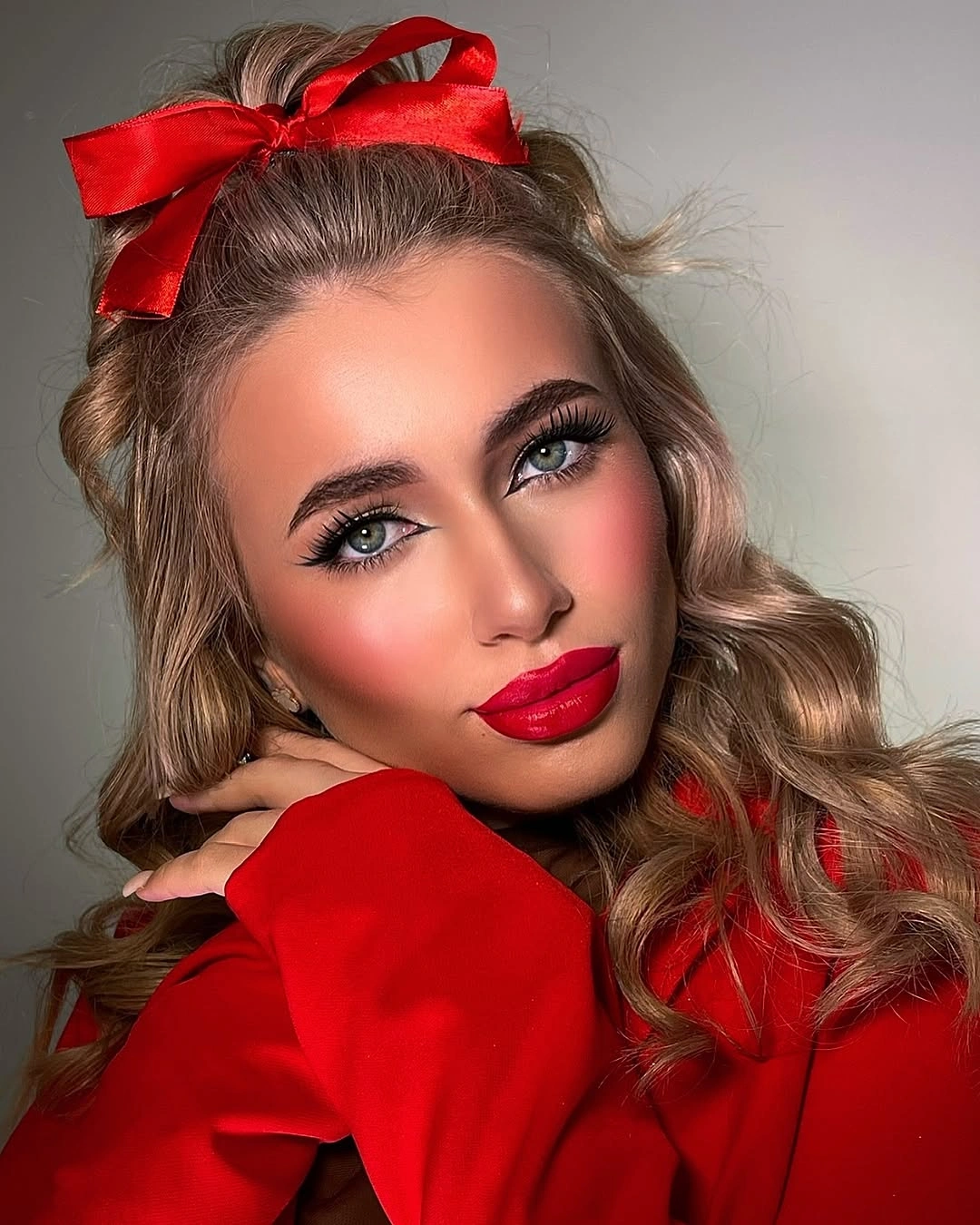Blonde loose curls with lifted crown and oversized red bow