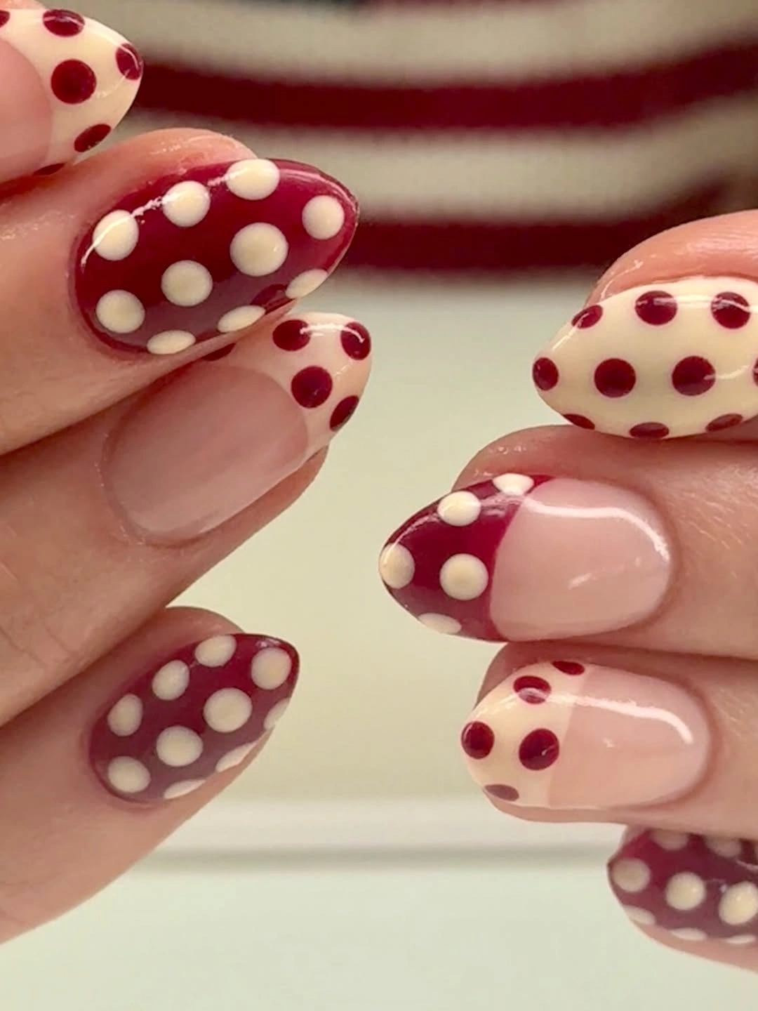 Rounded nails with burgundy and cream polka dots and dotted French tips
