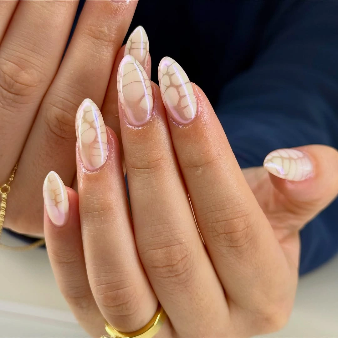 Long almond nails with ivory beige patterns and delicate lavender outlines