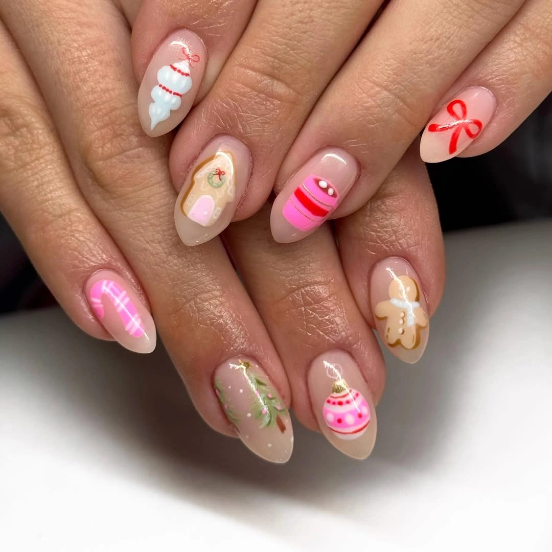 Nude almond nails with pink ornaments gingerbread red bows and Christmas decorations