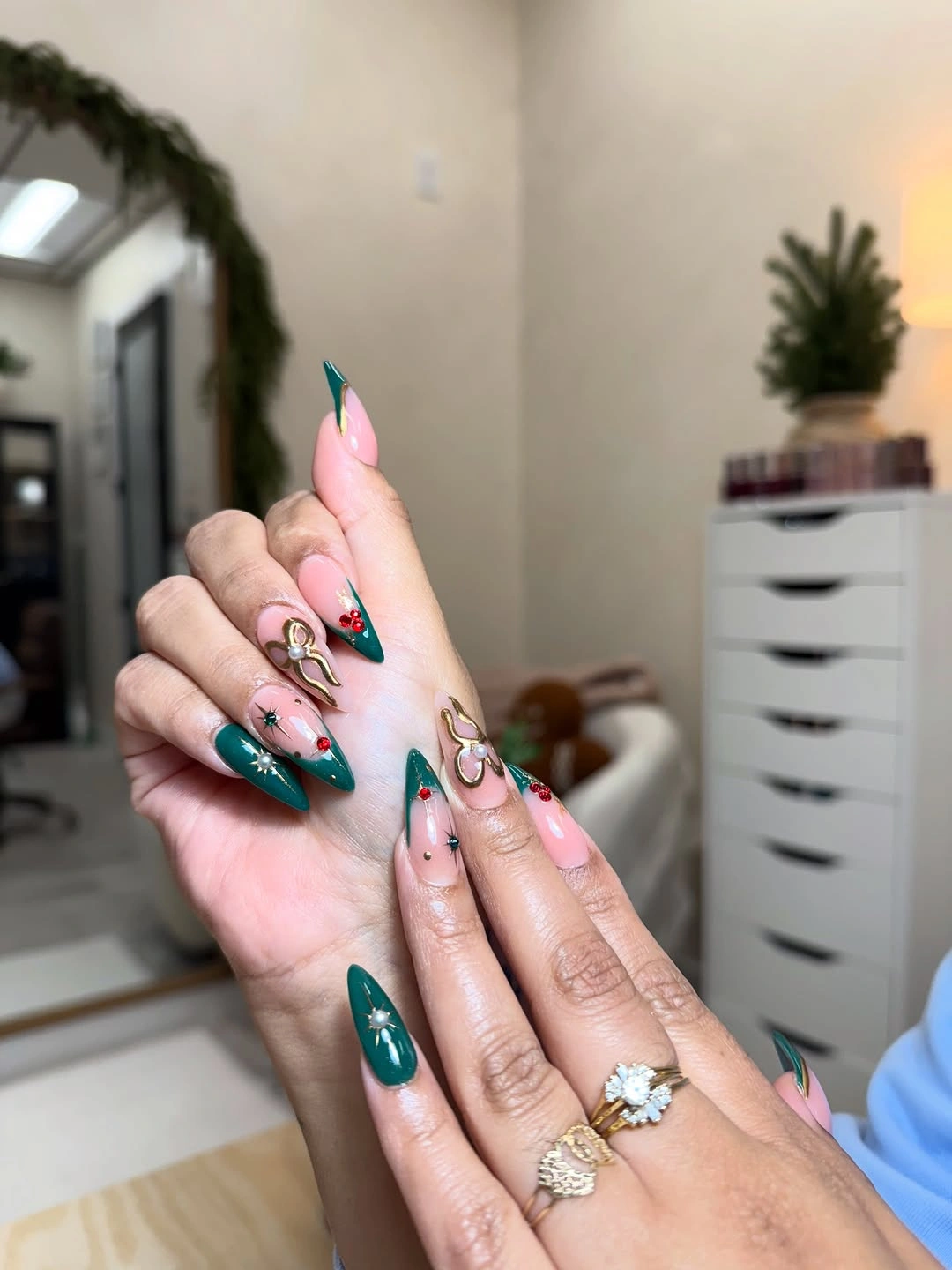 Long pointed green and pink nails with red berries gold bows and stars