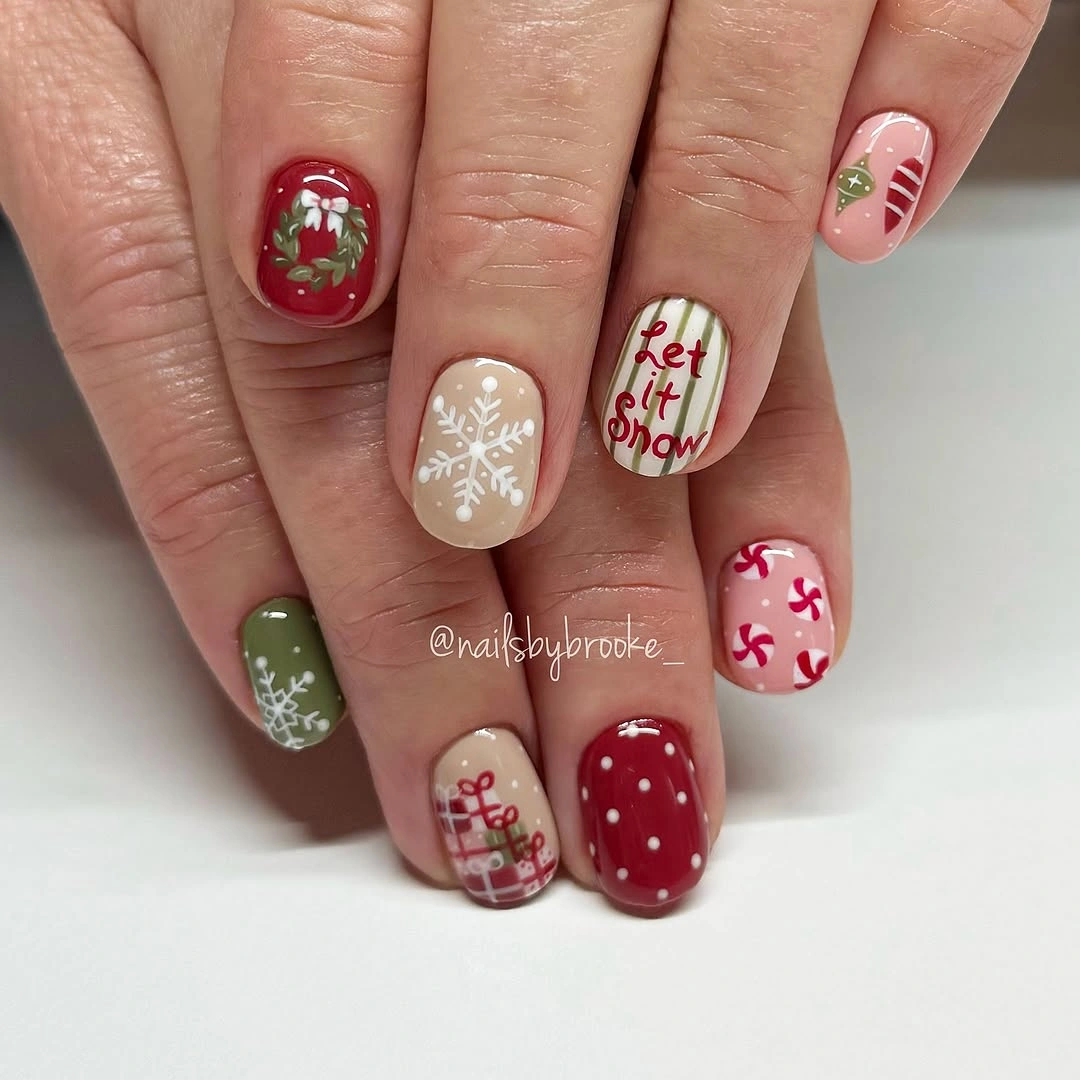 Short red, olive, and cream nails with snowflakes and handwritten lettering
